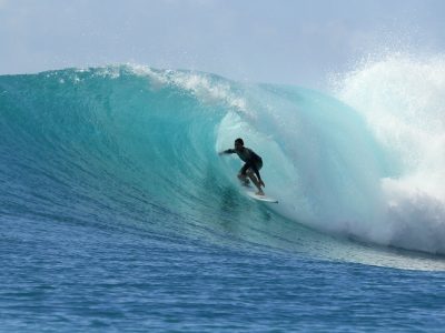 Surfero surfeando la una ola muy grande.