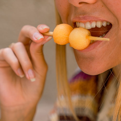 Chica disfrutando de un aperitivo sano e innovador con melón Waikiki.
