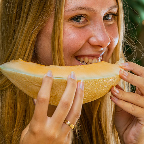 Un melón diferente, dulce, refrescante y delicioso. Mujer disfrutando de su sabor.